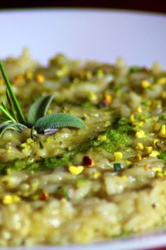 a white plate topped with rice and green garnish