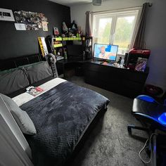 a bed room with a neatly made bed next to a window and a tv on the wall