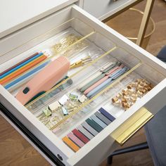 an organized drawer with pens, pencils and other items