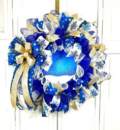 a blue and gold christmas wreath hanging on a door