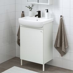 a white sink sitting under a bathroom mirror