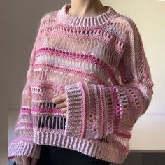 a woman wearing a pink and white knitted sweater