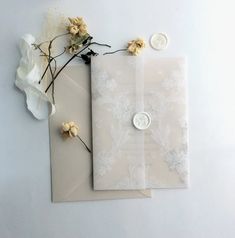 two envelopes with buttons and flowers on them