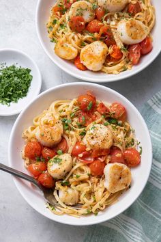 two white bowls filled with pasta and scallops