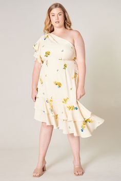 Soft spoken yellow floral bunches on a lightweight fabric shape a classy one shoulder style dress. A ruffle layered flouncy sleeve rests on the right shoulder, while a slim bodice flows into a flouncy asymmetrical ruffle hem. Perfect for attending any wedding or spring fling, pair it with strappy heels and you're good to go!- One shoulder- Ruffle layers- Slim bodice- Invisible zipper- Color: Ivory Yellow BlueSize + Fit - Model is 5'9" and wearing size 2X- Measurements taken from size 2X - Chest: Spring Dress With Asymmetrical Neckline And Ruffles, Spring Dress With Ruffles And Asymmetrical Neckline, Spring One Shoulder Dress With Ruffles For Brunch, Spring Brunch One Shoulder Dress With Ruffles, Spring Brunch One-shoulder Dress With Ruffles, Floral Print One Shoulder Dress For Brunch, Spring One Shoulder Dress With Floral Print, One Shoulder Floral Print Dress For Brunch, Spring One Shoulder Dress With Ruffle Hem