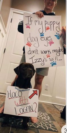 a man holding two signs with dogs on them