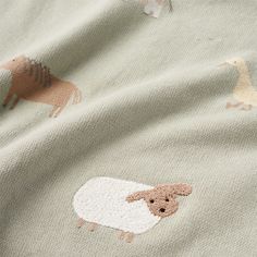 a close up of a blanket with sheep and ducks printed on it's side