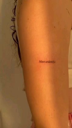 a woman's arm with the word most beautiful written in cursive font