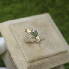 a ring that is sitting on top of a box with grass in the back ground