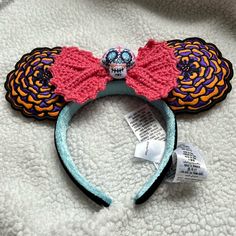 a close up of a minnie mouse ears headband on a white surface with tags around it