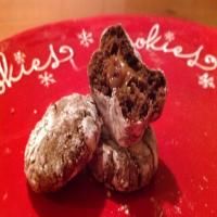 three cookies are on a red plate with white writing and snowflakes around them