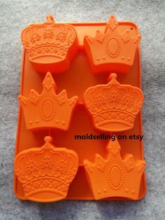 an orange plastic tray with six crown molds on it and the price is $ 9 00