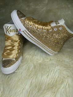 Custom Bling Converse All Star Chuck Taylor Sneakers. All designs handmade and embellished with a variety of high-quality crystals. Great for Quince's, weddings, proms, homecomings, birthdays, special events or just your everyday girly girl. Shoe Size: WOMEN'S size 5 to size 12 Size availability may vary based on our supplier's current inventory. If your size is out of stock at the time of your order, we will notify you within 48 hours. ** PLEASE NOTE CONVERSE CHUCK TAYLOR SNEAKERS RUN ABOUT A WHOLE SIZE BIG, IF YOU'VE NEVER HAD A PAIR, I STRONGLY RECOMMEND TRYING A PAIR ON TO ENSURE CORRECT SIZE. ** Gold high-top All-Star Converse Embellished with high quality gold crystals. Gold Satin ribbon laces (original shoestrings provided with all orders) (NEW SHOES GUARANTEED) THESE CAN BE CUSTOMI Bedazzled Shoes, Bling Converse, Pretty Sneakers, Ribbon Laces, Surprise Az, High Top Converse, Custom Bling, All Stars Converse, Sneakers Athletic