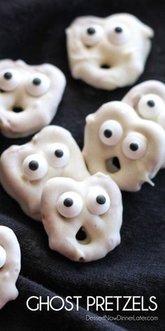 white ghost pretzels with googly eyes and black noses on a black cloth