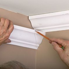 a man is painting the trim on a wall