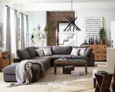 a living room filled with furniture and lots of plants on top of the floor next to a brick wall