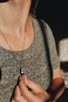 Lighthouse · Diamond Quartz, Moonstone, Smoky Quartz Necklace The different earthy tones in this piece is everything my neutral-loving self could ever want. Every necklace has the same order of stones: creamy white Moonstones anchoring the top and bottom, a sparkling clear Diamond Quartz, and two deeper Smoky Quartz crystals.The crystals are carefully positioned onto a bar that lays flat against your chest.Lightweight, works perfectly as an everyday piece.Adjustable chain length makes it so it c Elegant Jewelry With Moon Charm For Meditation, Minimalist Moon Phase Jewelry For Healing, Spiritual Moon Phase Necklace For Everyday Wear, Minimalist Everyday Necklaces With Moon Phase, Spiritual Moon Phase Necklace For Everyday, Everyday Spiritual Moon Phase Necklace, Sterling Silver Necklaces With Moon Charm For Meditation, Everyday Gemstone Round Pendant Necklace, Minimalist Moonstone Jewelry For Healing