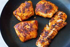 four pieces of chicken in a frying pan