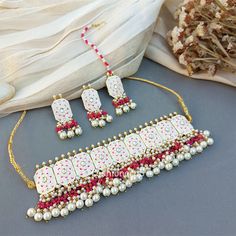 This Beautiful Meenakari White Colour Wedding Choker Necklace for Bride is very much in high trend gives you a real ethnic as well as royal look. Gold-toned Kundan Pearl Earrings have a floral base with stone-studded detail. This choker necklace set is designed for all age groups from college going girl to housewife. This is a piece of handcrafted kundan jewellery set with good quality Kundan and Pearl drops. For more, check out our latest fashion and kundan meena earrings and necklace set. Earr Traditional White Jewelry With Mirror Work, Ceremonial White Meenakari Jewelry Sets, White Meenakari Kundan Necklace For Ceremonial Occasions, Festive White Jeweled Kundan Necklace, White Jeweled Kundan Necklace For Festivals, Traditional White Meenakari Jewelry, Necklace For Bride, Wedding Choker Necklace, Colour Wedding