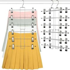 a skirt hanging on a clothes rack next to a pair of skirts with clips attached