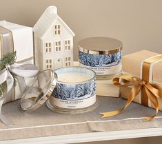 two candles sitting on top of a table next to presents