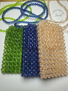 four beaded purses sitting on top of a white table next to each other