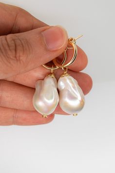 A simple, yet elegant gold-filled or sterling silver hoop earring with a single AAA baroque freshwater pearl charm. Specifications: Size: 2 x .5 inches Materials: 14k Gold, Sterling Silver, Freshwater Pearl 90-97% Clear, High Luster/Nacre All orders come with a handwritten note, a sturdy cardboard drawer box, and a velvet pouch. Note: Each piece is hand-selected and hand-made to order. All of our natural materials vary in size and detailing, so each piece is uniquely your own. Baroque Pearl Hoop Earrings With Pearl Charm, White Baroque Pearl Hoop Earrings With Charm, White Hoop Earrings With Baroque Pearl Charm, White Hoop Baroque Pearl Earrings, White Baroque Pearl Hoop Earrings, Round Hoop Earrings With Baroque Pearl Drop, Round Baroque Pearl Drop Hoop Earrings, Baroque Pearl Drop Dangle Hoop Earrings, Teardrop Baroque Pearl Jewelry With High Luster