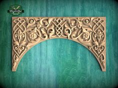 an intricate carved wooden arch on a green background