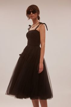 This cute off-the-shoulder cocktail midi gown is made of delicate tulle fabric. Featuring a straight neckline, a puffy tulle midi skirt with bow ties, and a lace-up closure on the back. Details:
  Material: Tulle 
 Fabric Composition: 100% polyester
 Sleeves style: Tie-straps 
 Silhouette: Princess silhouette 
 Skirt length from waist: 35.4 inches / 90 cm
 Dress weight: 1.7 lbs / 0.8 kg
 Neckline: Straight 
 Back: Lace-up corset
 Built-in cups
  Lining: Black full-length flared underskirt 
 Model is 180cm / 84-62-91, wearing size XS 
   
 Art.N.: 4000-19 Black Midi Tulle Dress, Milla Dresses, Midi Gown, Ukraine Art, Black Tulle Dress, Cold Moon, Skirt With Bow, Halloween 23, Midi Gowns