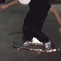 a young man riding a skateboard on top of a cement ground next to a car