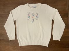 For the vintage fashion enthusiast, this Fire Islander sweater is a must-have. The ivory acrylic material is adorned with beautiful pastel cross-stitching in a floral pattern, giving it an arts and crafts look that is perfect for everyday wear. The sweater is a size L with a chest size of 39 inches and shoulder to hem measurement of 21 inches. This vintage Fire Islander sweater was made in the United States and is perfect for those who appreciate unique fashion pieces. The shoulder to shoulder measurement is 14.5 inches, making it a comfortable fit for regular size women. Whether you're into vintage clothing or simply love the floral design of this sweater, it's a great addition to any wardrobe. This sweater is in excellent vintage condition with no holes or stains. There is some minimal p Stitch Sweater, Fire Island, Floral Cross, Fashion Enthusiast, Floral Cross Stitch, Fashion Pieces, Cross Stitching, Mode Vintage, Design Floral