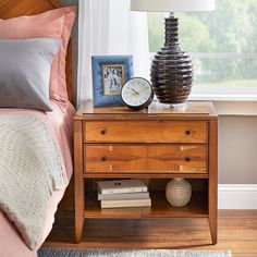 a bedroom with a bed, nightstand and window