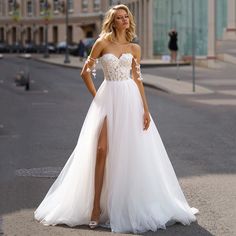 a woman in a white dress standing on the street