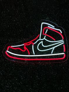 a neon light up shoe is shown on the black surface in front of a dark background