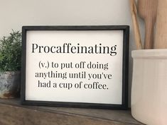 a framed sign that says procaflienting on it next to a potted plant