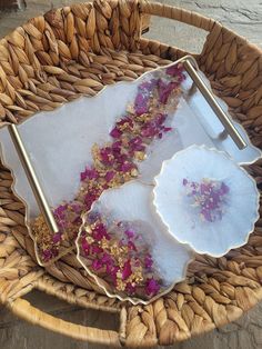 two plates with flowers on them sitting in a basket