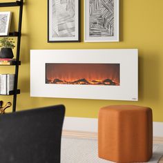 a living room with yellow walls and pictures on the wall, including an electric fireplace