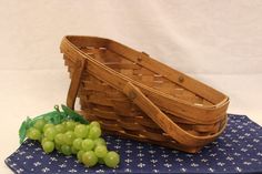 a wooden boat and grapes on a blue place mat with white stars in the background