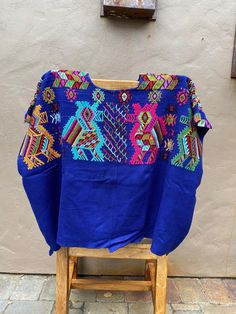 "Handwoven Guatemalan Huipil, Royal Blue Blouse with Bird Motifs, Vintage Chajul Textiles  Width: 23\" Length: 31\"  A woman may spend months weaving a single huipil when complex techniques or designs are required. Through the choices of design, material and finishing technique, information can be read about the weaver's birth-place, religious background, social position, weaving skill, and personality. Indigenous women can read the complex encoded messages in each other's huipiles at a glance.. Blue Printed Crew Neck Blouse, Blue Folk Style Short Sleeve Blouse, Traditional Blue Short Sleeve Blouse, Blue Short Sleeve Folk Blouse, Blue Short Sleeve Tops For Festivals, Embroidered Blue Tops For Festivals, Blue Embroidered Tops For Festivals, Traditional Blue Tops With Floral Embroidery, Bohemian Blue Blouse For Festivals