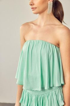 STYLE INFORMATION: The Monaco Milky Green Strapless Romper is a vacay dream! Light green woven fabric falls from a strapless neckline, with no-slip strips, to a flowy, ruffle overlay bodice with an on-trend smocked overlap back detail. Attached shorts complete the look. DETAILS & CARE: Lined Polyester/Rayon. Hand wash cold. Imported. SHIPPING: We offer free shipping for all orders in the Continental US. Strapless Smocked Back Tube Top For Summer, Strapless Tube Top With Smocked Back For Summer, Summer Strapless Tube Top With Smocked Back, Summer Bandeau Tube Top With Smocked Back, Strapless Summer Tube Top With Smocked Back, Spring Vacation Ruffled Tube Top, Summer Off-shoulder Smocked Back Tube Top, Summer Off-shoulder Tube Top With Ruffles, Summer Off-shoulder Tube Top With Smocked Back