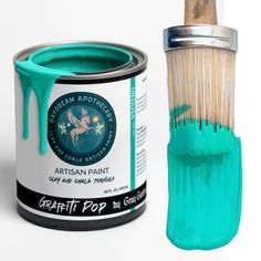 a can of paint next to a brush with green glaze on the top and bottom