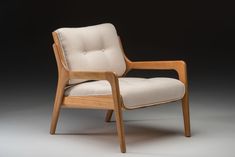 a wooden chair with white upholstered fabric on the armrests and back