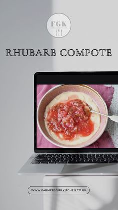 an open laptop computer sitting on top of a white table next to a bowl of food