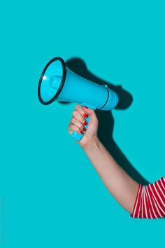 a woman holding a blue megaphone in her hand