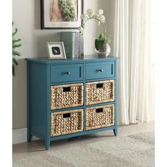 a blue dresser with wicker baskets in front of it and a framed photograph on the wall