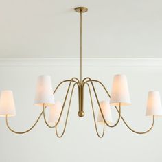 a chandelier with six lamps hanging from it's sides in a room