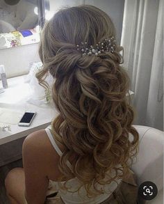 a woman sitting in front of a bathroom mirror