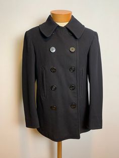 Vintage 1940s WWII era Navy Peacoat Size 38 10-button with chin strap and corduroy-lined hand warmer pockets. Fully lined. Tight fine woven wool for greater warmth. Great condition. Have some small holes. See photo. Size 38 20" across the chest 19" shoulder to shoulder  25" shoulder seam to cuff  31" from back neckline to hem Fall Pea Coat With Buttons For Tailoring, Fitted Military Pea Coat With Buttons, Classic Fitted Pea Coat With Snap Buttons, Wool Coat With Buttons For Cold Weather, Fitted Winter Peacoat With Buttons, Fitted Peacoat With Buttons For Winter, Solid Pea Coat With Buttons For Cold Weather, Fitted Military Wool Pea Coat, Military Style Fitted Wool Pea Coat