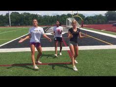 three girls are playing with a frisbee on the field