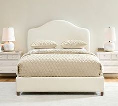 a white bed sitting in a bedroom next to two nightstands